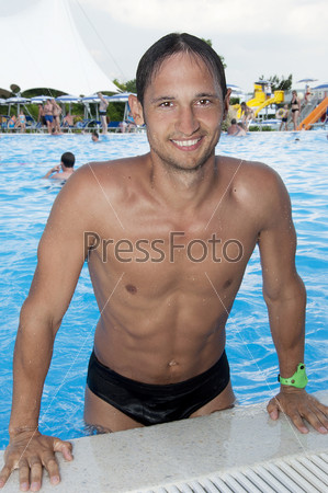Спортивный молодой человек в бассейне на курорте