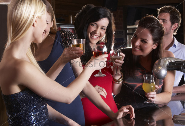 Четыре подруги с бокалами в ночном клубе