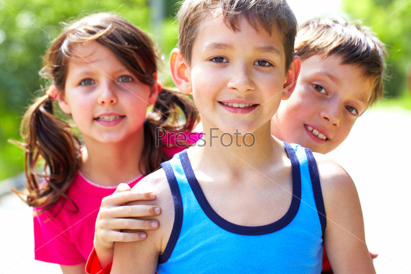 Portrait of three little friends looking at camera and smiling