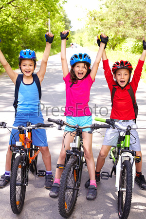 Portrait of three happy little cyclists