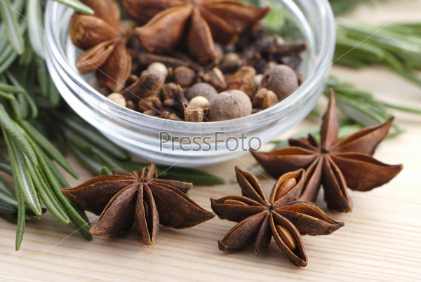 Rosemary, peppercorn, cloves and anise stars close-up in glass plate, stock photo