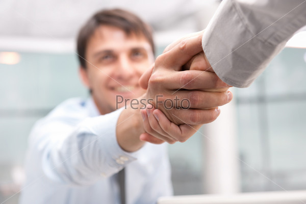 Closeup of business people shaking hands over a deal at office - Indoors
