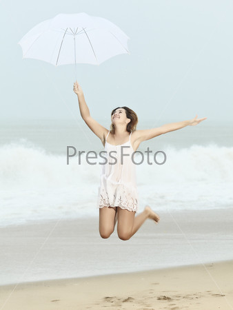 Beautiful woman near the stormy ocean at rain