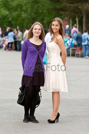 Two girls in a square in the background a lot of people, shallow depth of field, stock photo