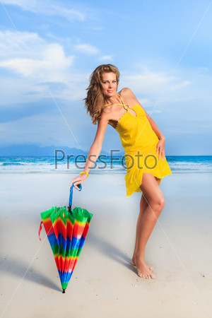 Woman in yellow dress on the beach