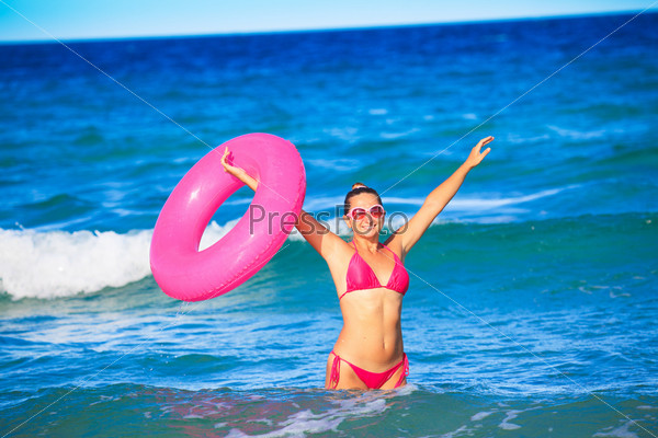 Happy woman with inner tube at the sea