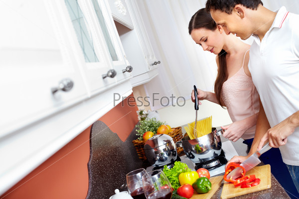 Молодая пара готовит на кухне