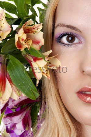 Half of beautiful female face closeup. Spring or summer makeup and flowers