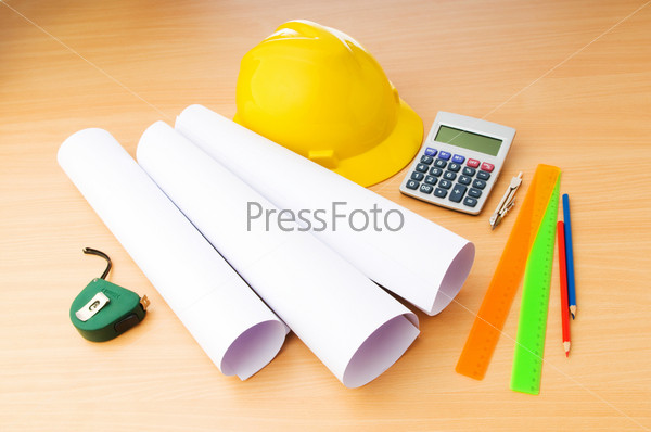 Drawings and hard hat on the desk, stock photo