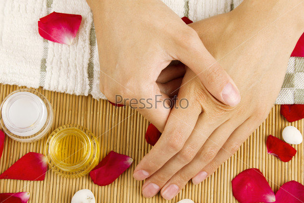 Close-up of girl lying on hand towel next to the cream, rose petals
