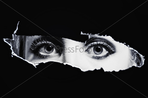 Women\'s bl eyes spying through a hole
