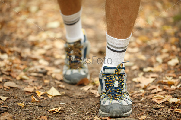 Мужские ноги в спортивных кроссовках крупным планом