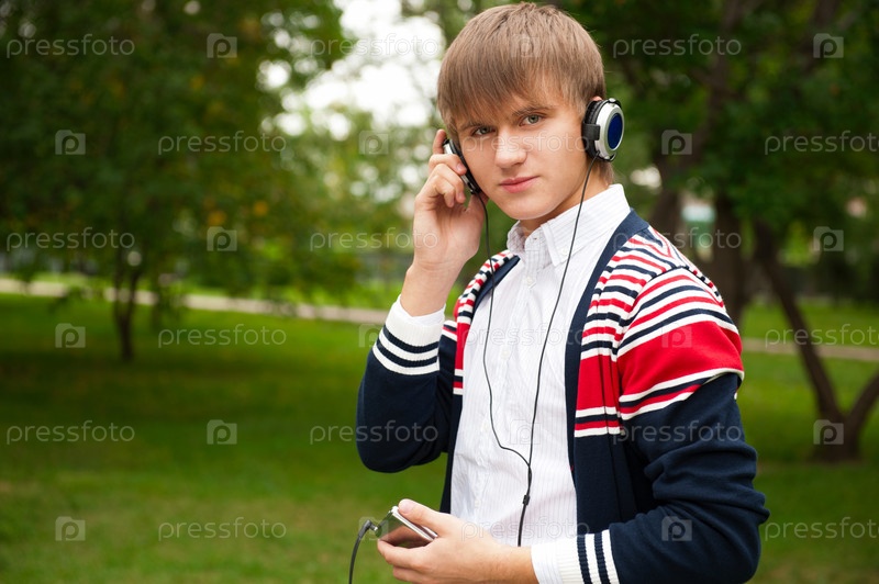 Student listening language course in headphones outside school