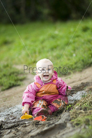 Happy 18-months-old Child playing in Mud
