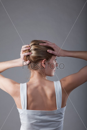 a girl stands with his back to the camera and holds hands hair