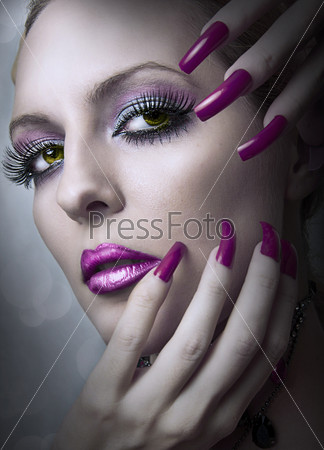 Portrait of beautiful woman of fashion bright evening make up and beauty purple manicure of fingernails . Female face closeup