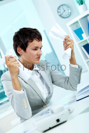 Image of young employer crumpling paper with troubled expression