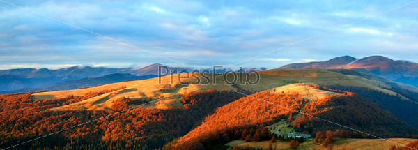 Autumn evening plateau landscape with lust golden sunlight on mountains and pink evening glow in sky. Two shots stitch image.