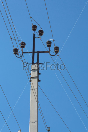 Электрический столб с проводами на фоне голубого неба