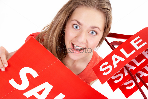 Portrait of amazed shopper with sale tags looking at camera