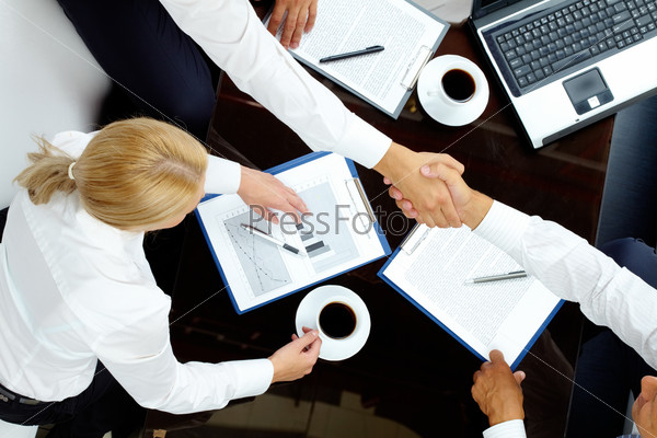 Image of successful partners handshaking after negotiations