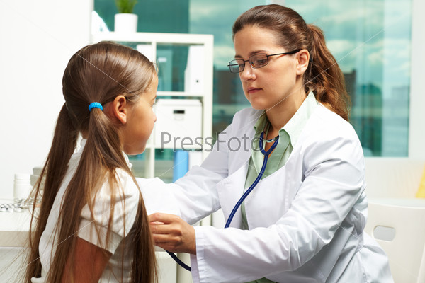 Portrait of serious clinician in eyeglasses examining youthful patient with stethoscope