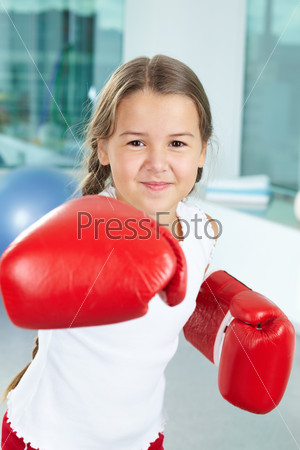 Девочка в боксерских перчатках в тренажерном зале