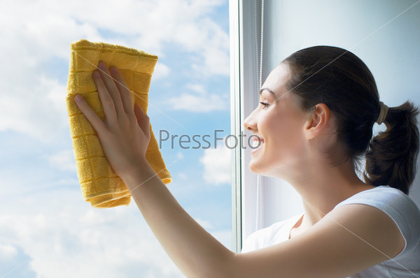 Молодая женщина моет окна