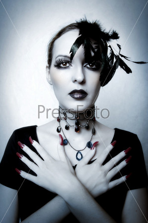 Gothic style fashion portrait of young woman vampire in black dress. Halloween concept. Dark make-up