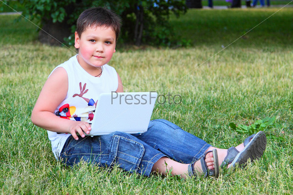 Мальчик с компьютером в парке