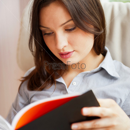 Young sexy woman at home reading book