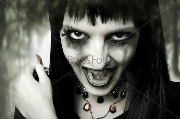 Halloween horror concept. Fashion portrait of witch or night vampire woman. Dark gothic makeup