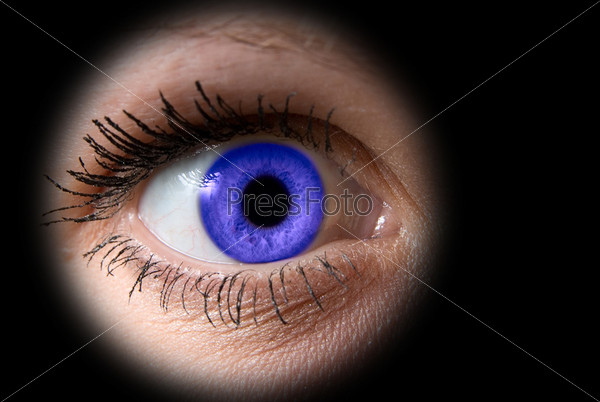 Женский глаз с фиолетовой линзой на черном фоне