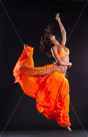 Beauty dancer jump in orange veil - arabian style