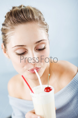 Beautiful woman drinking milk cocktail
