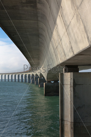 Curved Concrete Bridge over the water. Vertical shot