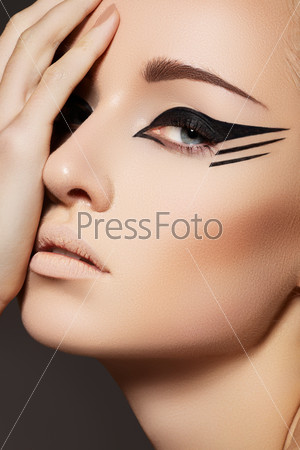 Glamourous closeup female portrait. Fashion eyeliner makeup on model eyes. Cosmetics and make-up. Sexy wild cat style