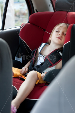 Sleeping child in auto baby seat in car