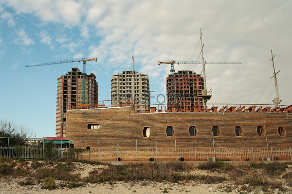 View of the construction of new homes in the city of Aktau. In the foreground is a cafe in the form of a ship.