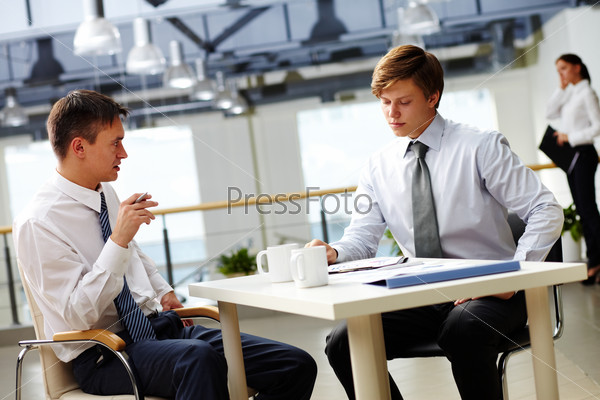 Two businessmen sitting at table and discussing strategy