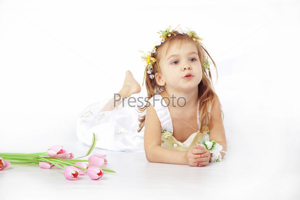 Little girl in spring flower dress isolated on white background with tulips