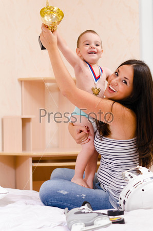 mother and son at home with golden cup