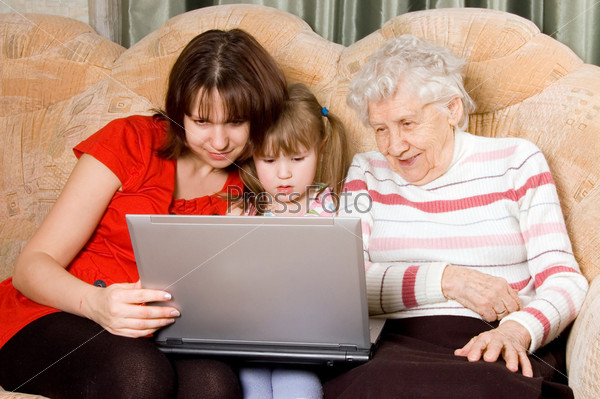 Семья на диване с компьютером