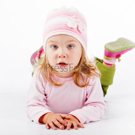 Pretty child lying and looking at camera on white background