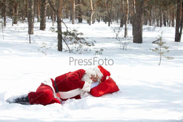 Санта, спящий на снегу в лесу