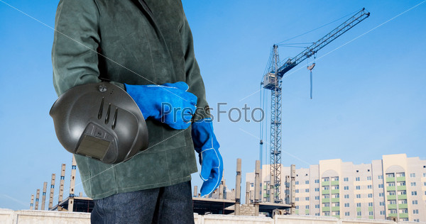 Male welder closeup with welding equipment on building background, stock photo