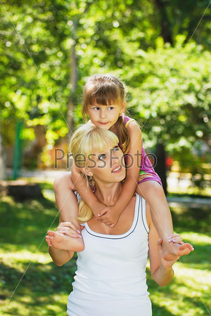 Mother and daughter playing in the meadow in the park