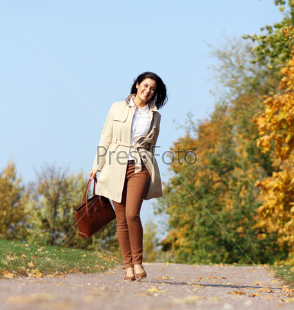 Full length, walking woman in autumn park
