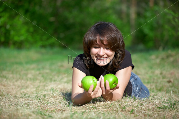 Beautiful young girl with two apples in hands