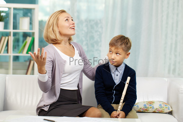 Portrait of pupil with the flute looking at his tutor speaking about music with admiration